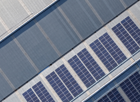 Aerial view of solar panels installed on the corrugated metal roof of an industrial factory building in Kilsyth South Melbourne VIC Australia. Aerial view of solar panels installed on the corrugated metal roof of an industrial factory building in Kilsyth South Melbourne VIC Australia.