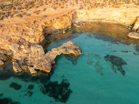 Aerial view of crystalline turquoise waters meet rugged sun kissed cliffs in a serene coastal embrace Blue lagoon Comino Malta. Aerial view of crystalline turquoise waters meet rugged sun kissed cliffs in a serene coastal embrace Blue lagoon Comino Malta.