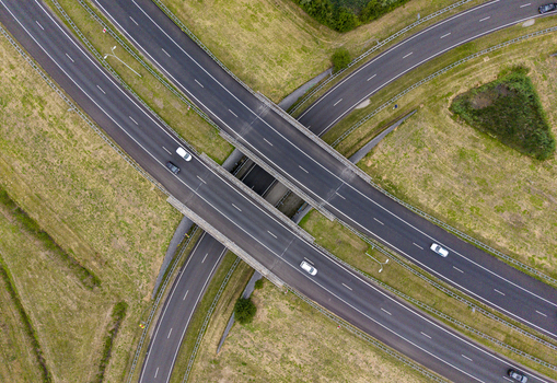 Aerial view of the Ekkersrijt highway interchange with vehicles driving on multi lane roads surrounded by green fields in Son Noord Brabant Netherlands.