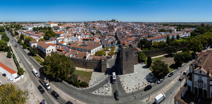 Aerial view of the historic city walls and medieval architecture of Evora featuring terracotta rooftops narrow streets and surrounding greenery in Evora Evora District Portugal. Aerial view of the historic city walls and medieval architecture of Evora featuring terracotta rooftops narrow streets and surrounding greenery in Evora Evora District Portugal.