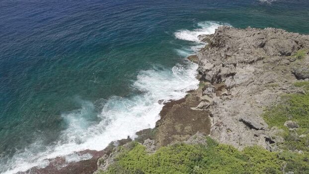 Aerial view of rocky coastline and waves in Siargao Philippines.