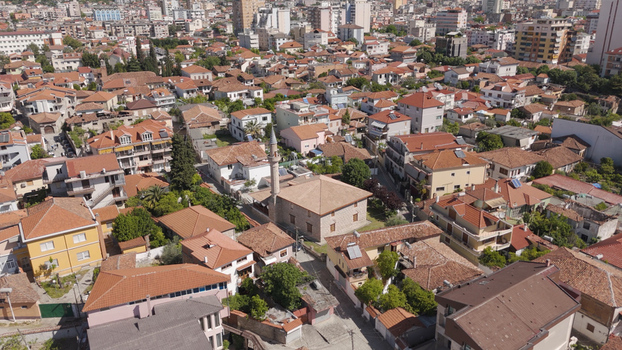 Aerial view of the historic King Mosque surrounded by traditional red tiled rooftops and urban residential buildings in Elbasan Qarku i Elbasanit Albania.