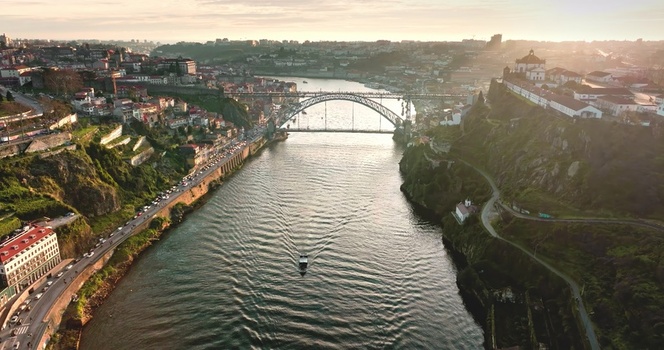 Aerial view of the Douro River and the iconic Dom Luis I Bridge at sunset with historic buildings lining the riverbanks in Porto Porto Portugal. Aerial view of the Douro River and the iconic Dom Luis I Bridge at sunset with historic buildings lining the riverbanks in Porto Porto Portugal.