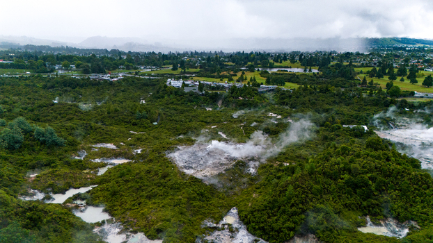 Aerial view of steam rising from geothermal pools amidst lush greenery a mystical landscape under a clouded sky Rotorua New Zealand. Aerial view of steam rising from geothermal pools amidst lush greenery a mystical landscape under a clouded sky Rotorua New Zealand.