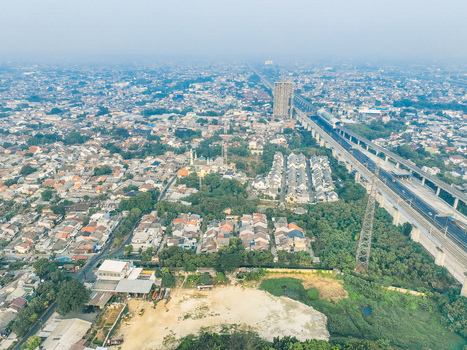 Aerial view of Cikunir residential area with dense housing lush trees and a prominent elevated highway overpass in Kecamatan Bekasi Selatan Jawa Barat Indonesia. Aerial view of Cikunir residential area with dense housing lush trees and a prominent elevated highway overpass in Kecamatan Bekasi Selatan Jawa Barat Indonesia.