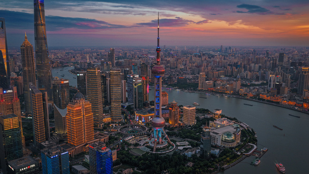 Aerial view of the Lujiazui skyline featuring the Oriental Pearl Tower and skyscrapers along the Huangpu River during a vibrant sunset in Shanghai Shanghai China. Aerial view of the Lujiazui skyline featuring the Oriental Pearl Tower and skyscrapers along the Huangpu River during a vibrant sunset in Shanghai Shanghai China.