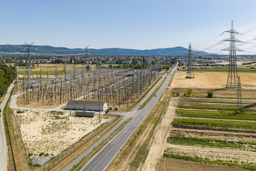 Aerial view of the Amprion Umspannwerk electrical substation with high voltage pylons and power lines surrounded by agricultural fields and a road in Pfungstadt Hessen Germany.