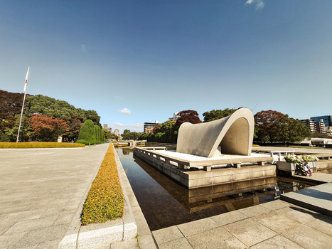View of the Cenotaph for the A bomb Victims in Hiroshima Peace Memorial Park with its arched concrete structure and reflecting pool in Hiroshima Hiroshima Japan. View of the Cenotaph for the A bomb Victims in Hiroshima Peace Memorial Park with its arched concrete structure and reflecting pool in Hiroshima Hiroshima Japan.