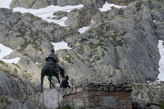 View of the bronze equestrian statue of General Suvorov at the Sankt Gotthard Pass surrounded by rugged rocky mountains and patches of snow in Airolo Ticino Switzerland.