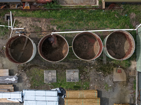 Melbourne VIC Australia 25 September 2026 Aerial view of industrial storage tanks surrounded by stacks of timber and machinery in an industrial yard.