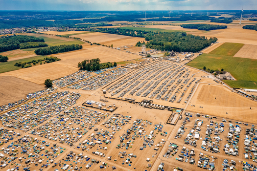 Herzogenaurach Germany 22 July 2022 Aerial view of the Open Beatz Festival campsite with thousands of tents and cars parked in fields under a summer sky. Herzogenaurach Germany 22 July 2022 Aerial view of the Open Beatz Festival campsite with thousands of tents and cars parked in fields under a summer sky.