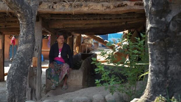 View of a woman sitting under a wooden shelter in Dhangadhi Nepal. View of a woman sitting under a wooden shelter in Dhangadhi Nepal.