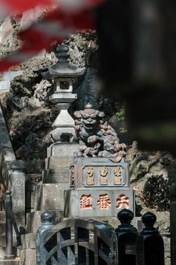 View of a weathered stone lantern and guardian statue stand sentinel amidst the rugged terrain of Naritasan Shinsho ji Narita Chiba Japan. View of a weathered stone lantern and guardian statue stand sentinel amidst the rugged terrain of Naritasan Shinsho ji Narita Chiba Japan.