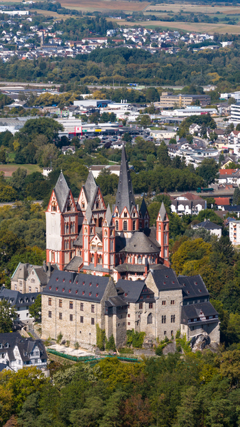 Aerial view of Limburg Cathedral with its distinctive spires and historic architecture surrounded by lush trees and the urban landscape of Limburg an der Lahn Hessen Germany. Aerial view of Limburg Cathedral with its distinctive spires and historic architecture surrounded by lush trees and the urban landscape of Limburg an der Lahn Hessen Germany.