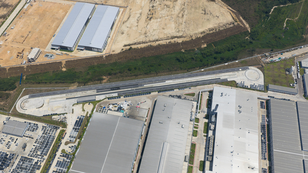 Aerial view of the BYD Auto Thailand factory complex featuring large industrial buildings extensive car storage lots and a test track in Phananikhom Rayong Thailand.