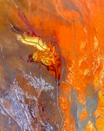 Aerial view of the vibrant mineral rich landscape of the Rio Tinto area featuring striking orange red and yellow earth patterns and cracked dry ground in Andalusia Spain. Aerial view of the vibrant mineral rich landscape of the Rio Tinto area featuring striking orange red and yellow earth patterns and cracked dry ground in Andalusia Spain.