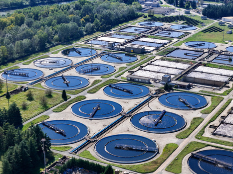 Aerial view of the Impianto depurazione water treatment plant featuring circular sedimentation tanks and rectangular basins Castiglione Torinese Piedmont Italy.