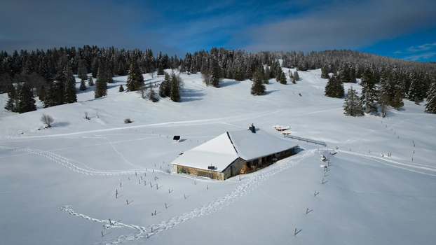 Aerial view of a snow covered cabin nestled amongst the trees a winter haven bathed in soft sunlight Mijoux Auvergne Rhône Alpes France. Aerial view of a snow covered cabin nestled amongst the trees a winter haven bathed in soft sunlight Mijoux Auvergne Rhône Alpes France.