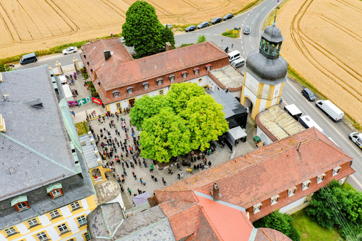 Eggolsheim Germany 09 May 2026 Aerial view of Schloss Jagersburg with people gathered in the courtyard red tiled roofs and a historic tower surrounded by golden fields. Eggolsheim Germany 09 May 2026 Aerial view of Schloss Jagersburg with people gathered in the courtyard red tiled roofs and a historic tower surrounded by golden fields.