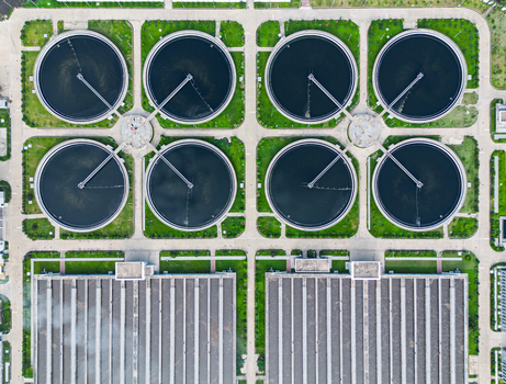 Aerial view of the Sewage Treatment Plant Dhaka WASA featuring circular clarifier tanks and industrial buildings surrounded by green lawns in Dhaka Dhaka Division Bangladesh. Aerial view of the Sewage Treatment Plant Dhaka WASA featuring circular clarifier tanks and industrial buildings surrounded by green lawns in Dhaka Dhaka Division Bangladesh.