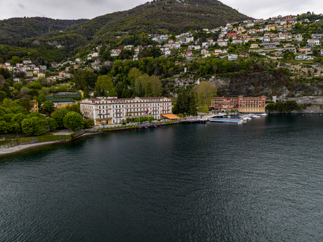 Aerial view of Villa d Este luxury hotel on the shores of Lake Como with its floating pool and green hills in Cernobbio Lombardia Italy. Aerial view of Villa d Este luxury hotel on the shores of Lake Como with its floating pool and green hills in Cernobbio Lombardia Italy.