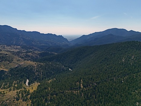 Aerial view of the mountainous landscape near Crescent Meadows Trailhead featuring dense pine forests rugged slopes and a winding valley in Golden Colorado United States. Aerial view of the mountainous landscape near Crescent Meadows Trailhead featuring dense pine forests rugged slopes and a winding valley in Golden Colorado United States.
