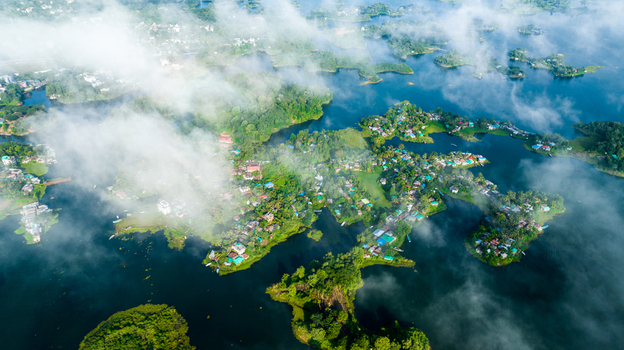 Rangamati Bangladesh 19 October 2022 Aerial view of Rangamati with lush green islands scattered houses and calm lake waters partially obscured by low hanging clouds.