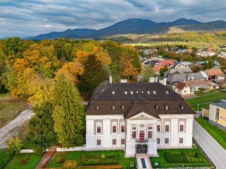 Aerial view of an elegant white manor house vibrant autumn trees and distant mountains under a dramatic sky Mosovce Zilina Region Slovakia. Aerial view of an elegant white manor house vibrant autumn trees and distant mountains under a dramatic sky Mosovce Zilina Region Slovakia.