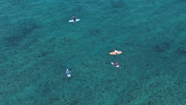 Aerial view of surfers in turquoise waters Maldives. Aerial view of surfers in turquoise waters Maldives.