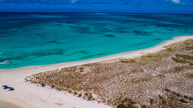 Aerial view of the turquoise waters and white sandy beaches of the Los Roques archipelago with small boats anchored near the shore Los Roques Dependencias Federale Venezuela. Aerial view of the turquoise waters and white sandy beaches of the Los Roques archipelago with small boats anchored near the shore Los Roques Dependencias Federale Venezuela.