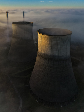 Aerial view of the RWE Clauscentrale cooling towers emerging from a thick layer of morning fog under a clear sky Maasbracht Limburg Netherlands. Aerial view of the RWE Clauscentrale cooling towers emerging from a thick layer of morning fog under a clear sky Maasbracht Limburg Netherlands.