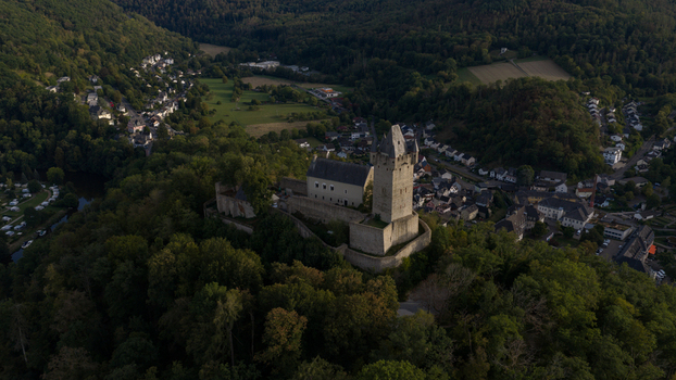 Aerial view of Nassau Castle on a forested hill overlooking the town with historic stone walls and a tall tower surrounded by lush green trees Nassau Rheinland Pfalz Germany.