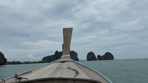 View of longtail boat and limestone karsts Thailand.
