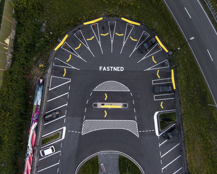 Aerial view of a Fastned electric vehicle charging station with yellow parking markings and parked cars in Amsterdam Noord Holland Netherlands. Aerial view of a Fastned electric vehicle charging station with yellow parking markings and parked cars in Amsterdam Noord Holland Netherlands.