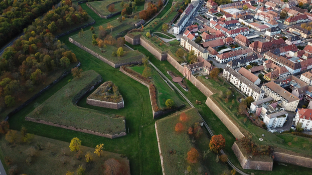 Aerial view of the historic Vauban walled city of Neuf Brisach with its star shaped fortifications green ramparts and adjacent urban buildings in Neuf Brisach Grand Est France. Aerial view of the historic Vauban walled city of Neuf Brisach with its star shaped fortifications green ramparts and adjacent urban buildings in Neuf Brisach Grand Est France.