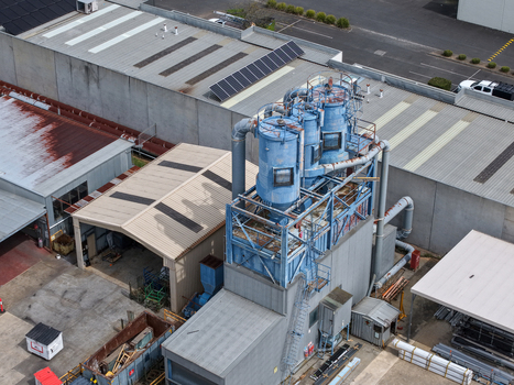 Melbourne VIC Australia 25 September 2026 Aerial view of industrial site with blue dust collection silos factory rooftops with solar panels and warehouse facilities.