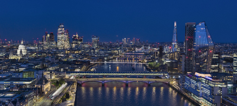Aerial view of the City of London skyline at night featuring the River Thames St Paul s Cathedral and illuminated skyscrapers in London England United Kingdom.
