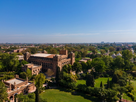 Aerial view of the historic Islamia College University Peshawar surrounded by lush green lawns and trees under a clear blue sky in Peshawar Khyber Pakhtunkhwa Pakistan. Aerial view of the historic Islamia College University Peshawar surrounded by lush green lawns and trees under a clear blue sky in Peshawar Khyber Pakhtunkhwa Pakistan.