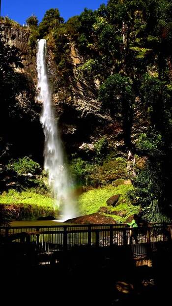 View of a waterfall and wooden bridge New Zealand.