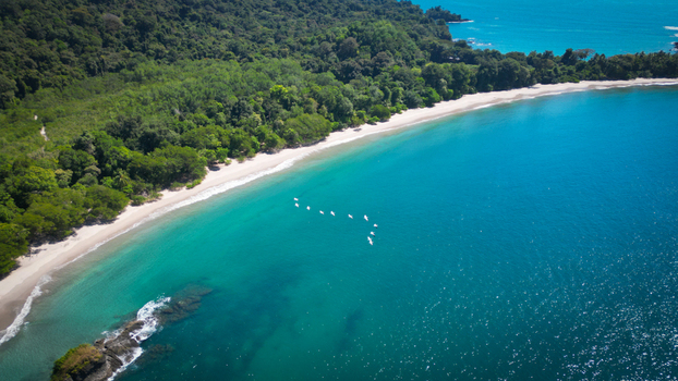 Aerial view of turquoise waters meet the lush green forests along the sandy coastline Quepos Puntarenas Province Costa Rica. Aerial view of turquoise waters meet the lush green forests along the sandy coastline Quepos Puntarenas Province Costa Rica.
