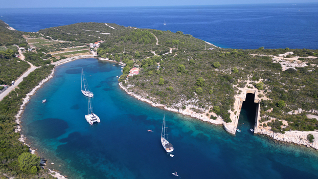 Aerial view of Potkop Parja boat shelter and sailboats in a turquoise bay surrounded by lush green hills in Rogacic Splitsko dalmatinska Croatia. Aerial view of Potkop Parja boat shelter and sailboats in a turquoise bay surrounded by lush green hills in Rogacic Splitsko dalmatinska Croatia.