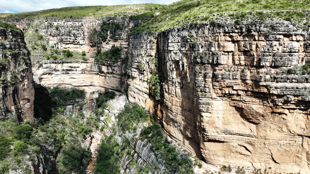 Aerial view of El Vergel canyon featuring steep layered rock walls lush green vegetation clinging to the cliffs and a river flowing through the deep gorge in Torotoro Potosi Department Bolivia. Aerial view of El Vergel canyon featuring steep layered rock walls lush green vegetation clinging to the cliffs and a river flowing through the deep gorge in Torotoro Potosi Department Bolivia.
