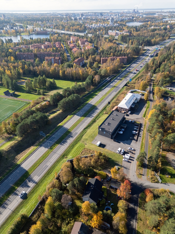 Aerial view of a traffic scene on a highway surrounded by autumn forests residential buildings and green spaces in Oulu North Ostrobothnia Finland. Aerial view of a traffic scene on a highway surrounded by autumn forests residential buildings and green spaces in Oulu North Ostrobothnia Finland.