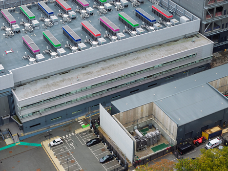 Aerial view of a data center with rooftop cooling units industrial infrastructure and parking area in United Kingdom.