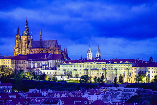 Aerial view of Prague Castle illuminated at night with historic gothic architecture and surrounding rooftops in Prague Prague Czechia. Aerial view of Prague Castle illuminated at night with historic gothic architecture and surrounding rooftops in Prague Prague Czechia.