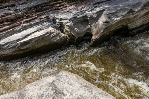 View of Estrecho del Rio Magdalena with turbulent water flowing through a narrow rocky gorge featuring layered stone formations in San Agustin Huila Colombia.