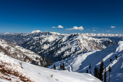 View of snow covered mountains under a clear blue sky create a striking contrast in winter s embrace a scene of icy peaks and frosted valleys Haveli Azad Kashmir Pakistan.