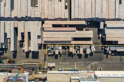 Aerial view of organized stacks of industrial pallets and warehouse storage area with piping and asphalt ground in Kyjov South Moravian Region Czechia.