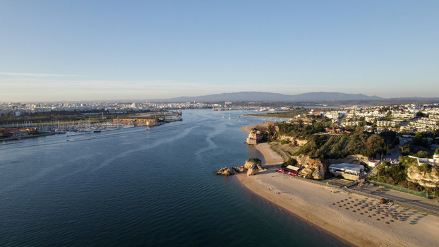 Aerial view of the Arade River estuary sandy beaches coastal cliffs and the town skyline in Ferragudo Faro District Portugal.