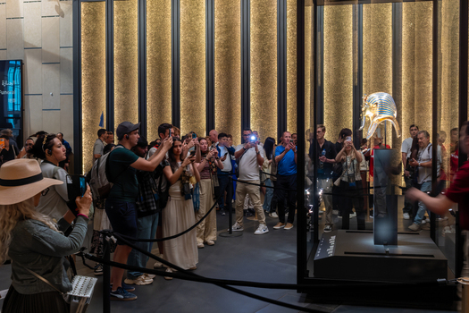 Giza Egypt 16 May 2026 View of tourists photographing the golden mask of Tutankhamun inside a display case at The Grand Egyptian Museum. Giza Egypt 16 May 2026 View of tourists photographing the golden mask of Tutankhamun inside a display case at The Grand Egyptian Museum.